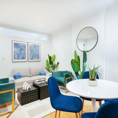 Modern NYC apartment living room with blue chairs and plants