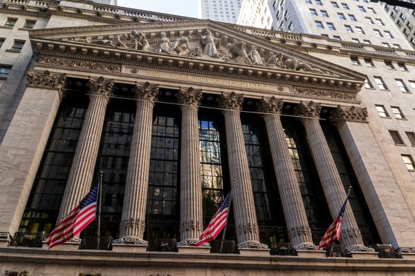 New York Stock Exchange building with American flags on Wall Street