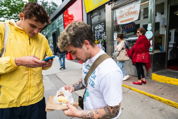 Friends eating knishes outside Yonah Schimmel's on the Lower East Side